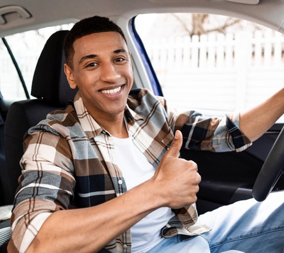 Man gives thumbs-up in car